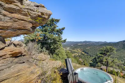 a hot tub on the side of a rocky mountain at The View at Mountain Retreat By Red Rocks and Golden in Evergreen