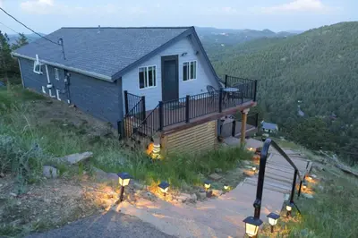 a house on a hill with lights in front of it at The View at Mountain Retreat By Red Rocks and Golden in Evergreen