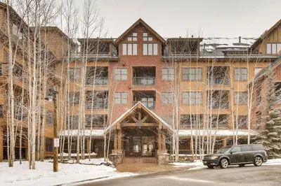 a car parked in front of a large brick building at The Springs Condominiums by Vail Resorts in Keystone