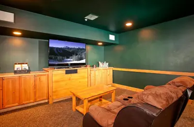 a living room with a couch and a large screen tv at The Springs Condominiums by Vail Resorts in Keystone