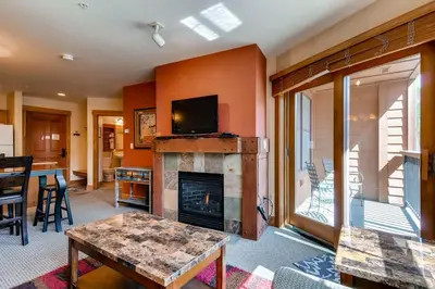 a living room with a fireplace and a tv at The Springs Condominiums by Vail Resorts in Keystone