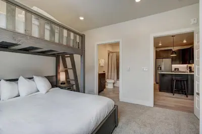 a bedroom with a loft bed and a kitchen at Clearwater Lofts by Vail Resorts in Keystone
