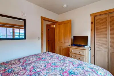 a bedroom with a bed and a television on a dresser at Expedition Station Condos by Vail Resorts in Keystone