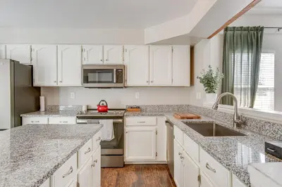 a kitchen with white cabinets and granite counter tops at 6 Mi to Dtwn Arvada Home with Hot Tub and Yard in Arvada