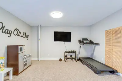 a room with a gym with a treadmill and a flat screen tv at 6 Mi to Dtwn Arvada Home with Hot Tub and Yard in Arvada