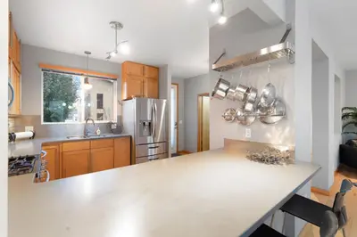 a kitchen with a white counter top and a refrigerator at Sleek Home near Old Town with Rooftop Hot Tub & Mtn Views in Fort Collins