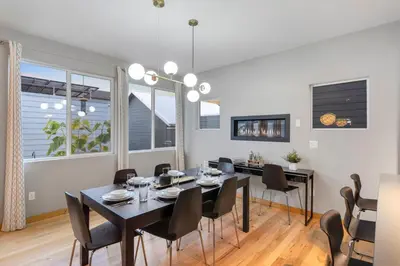 a dining room with a black table and chairs at Sleek Home near Old Town with Rooftop Hot Tub & Mtn Views in Fort Collins