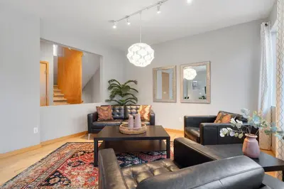 a living room with couches and a table at Sleek Home near Old Town with Rooftop Hot Tub & Mtn Views in Fort Collins