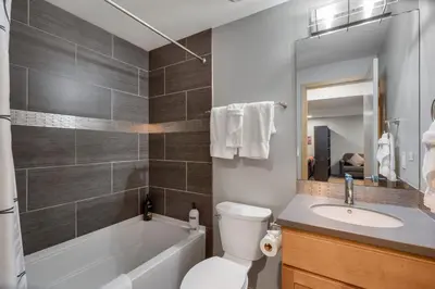 a bathroom with a tub and a toilet and a sink at Sleek Home near Old Town with Rooftop Hot Tub & Mtn Views in Fort Collins