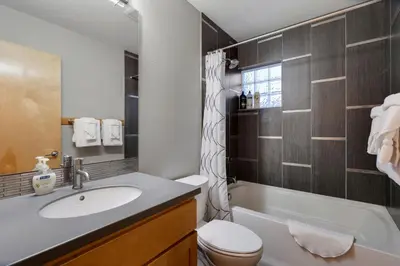 a bathroom with a sink and a toilet and a tub at Sleek Home near Old Town with Rooftop Hot Tub & Mtn Views in Fort Collins