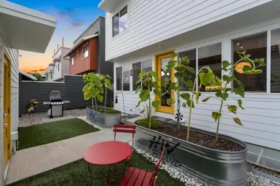a house with a patio with red chairs and a table at Sleek Home near Old Town with Rooftop Hot Tub & Mtn Views in Fort Collins