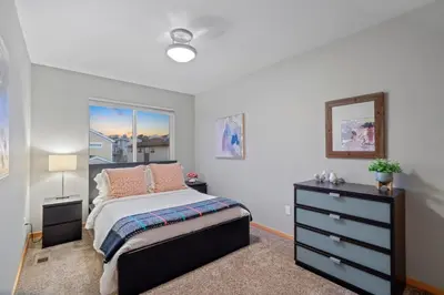 a bedroom with a bed and a dresser and a window at Sleek Home near Old Town with Rooftop Hot Tub & Mtn Views in Fort Collins