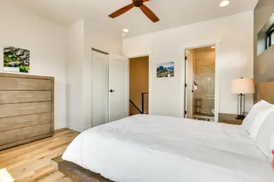 a bedroom with a white bed and a ceiling fan at Sleek Fraser Townhome Less Than 8 Mi to Winter Park! in Fraser