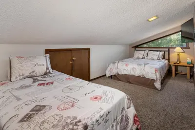 a bedroom with two beds and a table with a lamp at Twin Rivers Vasquez 3 by Stay Winter Park in Fraser