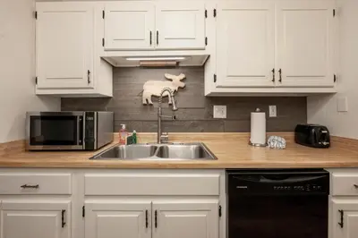 a kitchen with white cabinets and a sink at Twin Rivers Vasquez 3 by Stay Winter Park in Fraser