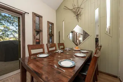 a dining room with a wooden table and a mirror at Twin Rivers Vasquez 3 by Stay Winter Park in Fraser