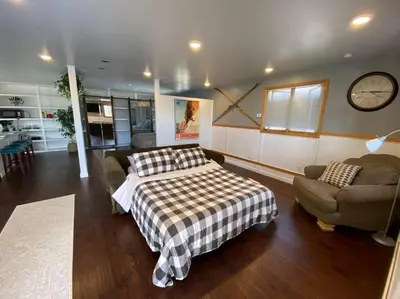 a bedroom with a bed and a couch and a clock at Roof-top stay, king-size bed, views of Loveland in Loveland
