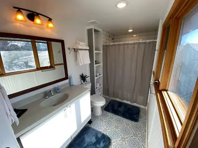 a bathroom with a sink and a toilet and a mirror at Roof-top stay, king-size bed, views of Loveland in Loveland