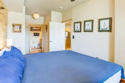 a bedroom with a blue bed in a room at Condo Near Winter Park Resort and Steps From Shuttle in Fraser