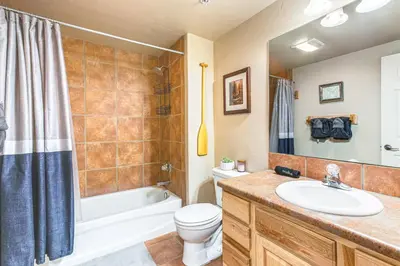 a bathroom with a sink and a toilet and a tub at Condo Near Winter Park Resort and Steps From Shuttle in Fraser