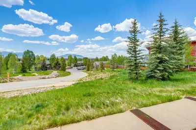 a road with green grass and trees on the side at Condo Near Winter Park Resort and Steps From Shuttle in Fraser