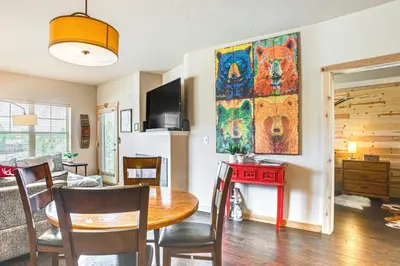 a kitchen and dining room with a table and a painting on the wall at Condo Near Winter Park Resort and Steps From Shuttle in Fraser