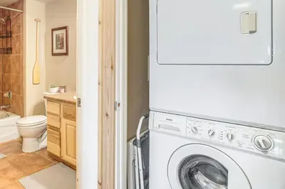 a white washer and dryer in a bathroom at Condo Near Winter Park Resort and Steps From Shuttle in Fraser