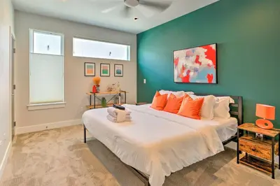 a bedroom with a large bed with orange pillows at City Skyline Views Upscale Denver Townhome in Denver