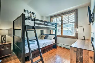 a bedroom with two bunk beds and a desk at Winter Park Condo with Mountain Views and Hot Tub in Winter Park
