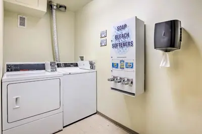 a laundry room with a washer and a sign on the wall at Winter Park Condo with Mountain Views and Hot Tub in Winter Park