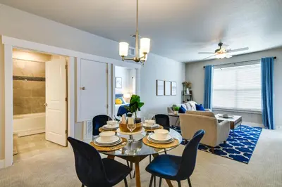 a dining room and living room with a table and chairs at Elegant Loveland Condo Less Than 5 Mi to Old Town! in Loveland
