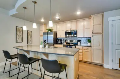 a kitchen with a large island with chairs around it at Elegant Loveland Condo Less Than 5 Mi to Old Town! in Loveland