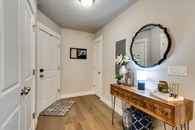 a hallway with a mirror and a wooden table at Elegant Loveland Condo Less Than 5 Mi to Old Town! in Loveland