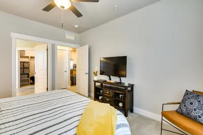 a bedroom with a bed and a flat screen tv at Elegant Loveland Condo Less Than 5 Mi to Old Town! in Loveland