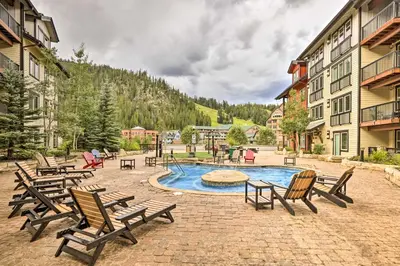 a group of chairs sitting around a swimming pool at Charming Winter Park Condo - Steps to Slopes! in Winter Park