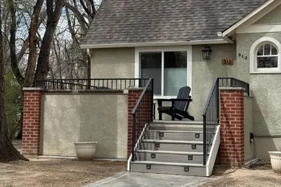 a house with a deck with a chair on it at Elegant Old Town Charm - Walk to CSU and Downtown in Fort Collins