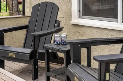 two black chairs sitting next to a window with two soda cans at Elegant Old Town Charm - Walk to CSU and Downtown in Fort Collins
