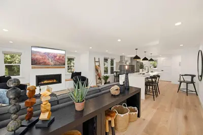 a living room and kitchen with a couch and a fireplace at Elegant Old Town Charm - Walk to CSU and Downtown in Fort Collins