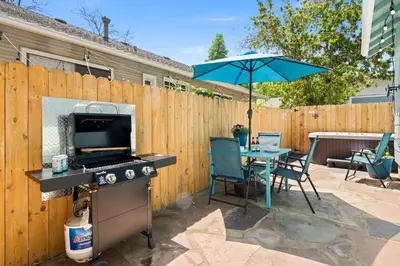 a patio with a table and an umbrella at Downtown Abode with Hot Tub - Walk to CSU & Old Town in Fort Collins