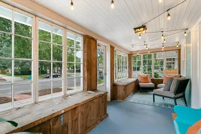 a room with windows and a couch and a chair at Downtown Abode with Hot Tub - Walk to CSU & Old Town in Fort Collins