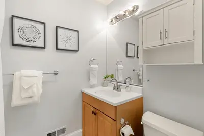a white bathroom with a sink and a toilet at Downtown Abode with Hot Tub - Walk to CSU & Old Town in Fort Collins