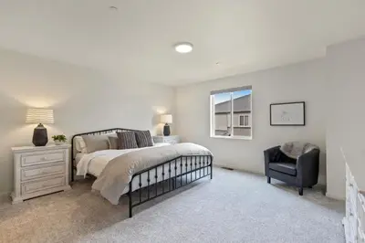 a bedroom with a bed and a chair and a window at NEW! Cozy Colorado Living - 8 min from Old Town! in Fort Collins