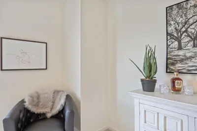 a living room with a chair with a cactus at NEW! Cozy Colorado Living - 8 min from Old Town! in Fort Collins