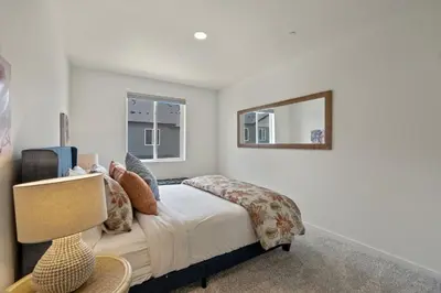 a bedroom with a bed and a mirror at NEW! Cozy Colorado Living - 8 min from Old Town! in Fort Collins