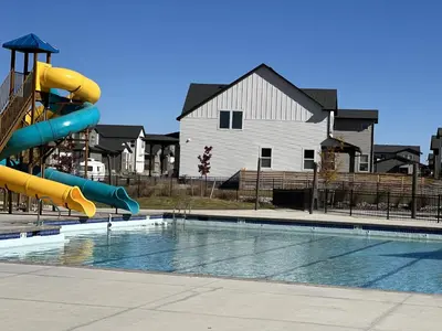 a swimming pool with a slide in front of a house at NEW! Cozy Colorado Living - 8 min from Old Town! in Fort Collins