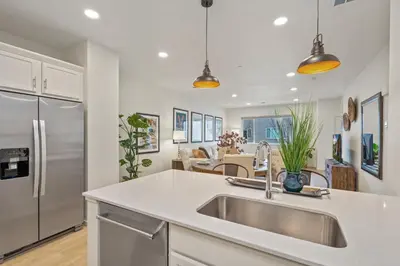 a kitchen with a sink and a stainless steel refrigerator at NEW! Cozy Colorado Living - 8 min from Old Town! in Fort Collins