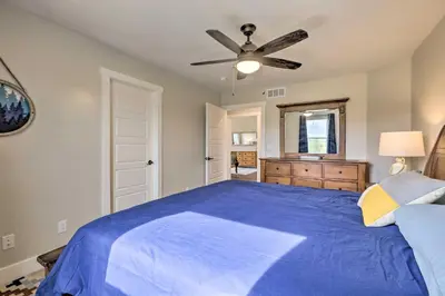 a bedroom with a blue bed and a ceiling fan at Walk To Golf Modern Mtn-View Home in Granby in Granby