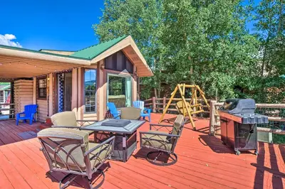 a deck with a grill and chairs and a playground at 6 Mi to Ski Resort! Lakefront Breckenridge Cabin in Breckenridge