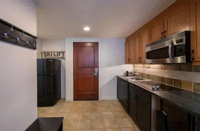 a kitchen with wooden cabinets and a black refrigerator at Winter Park FF Premium-Rated 4470 in Winter Park