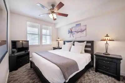 a bedroom with a bed with a ceiling fan and a television at Winter Park FF Premium-Rated 4470 in Winter Park